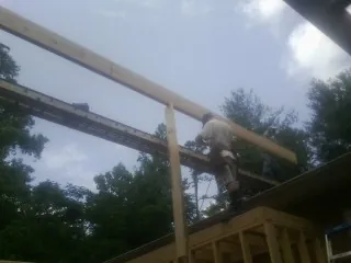 Carpenter setting a ridge beam over a new addition frame — Ice Dam Removal by Roofing Brothers in Goose Lake