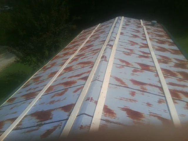 Rusted metal roof panels with new wood purlins before replacement — Storm Damage Roof Repair in Goose Lake by Roofing Brothers