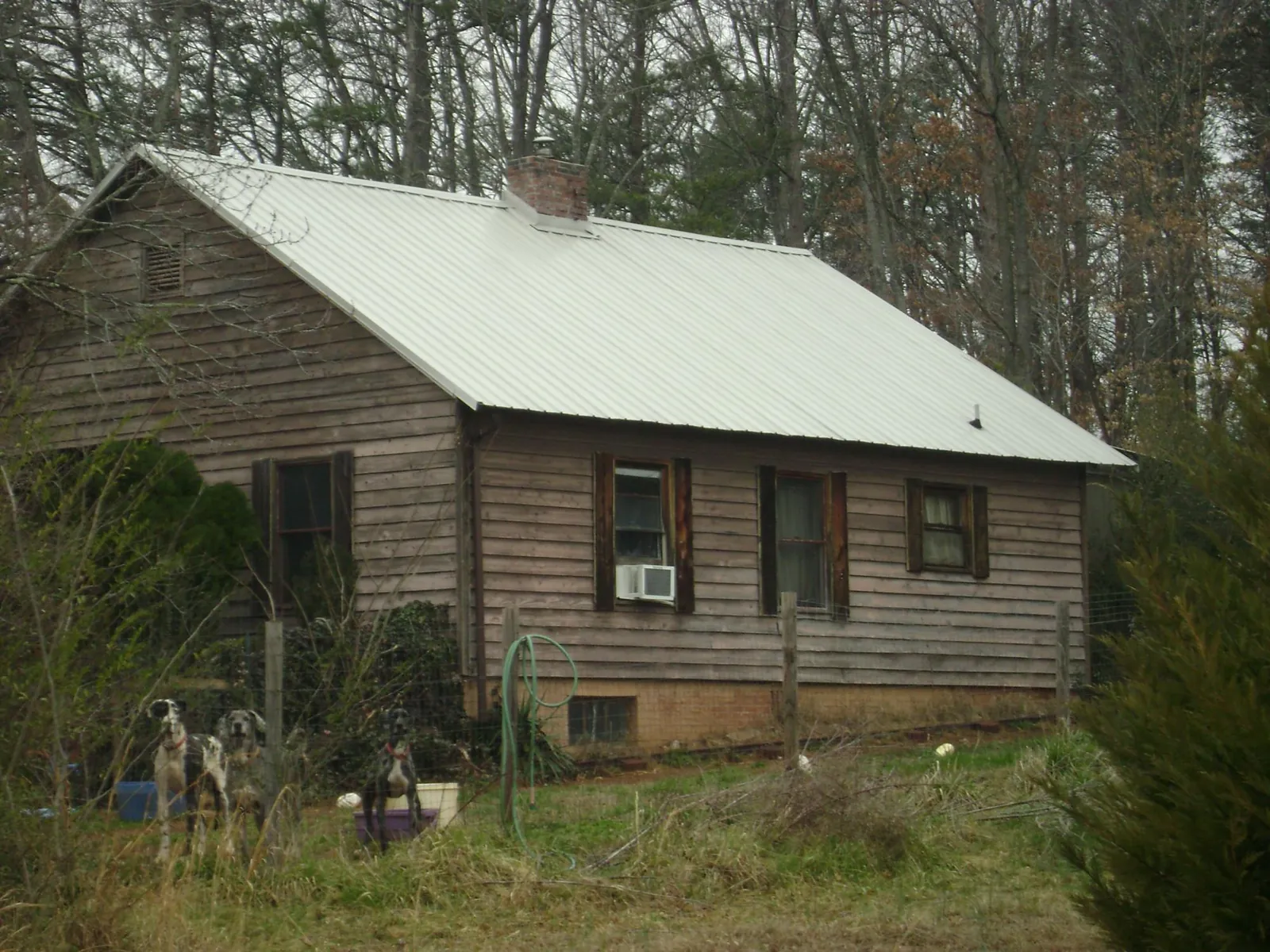 White metal roof on an old wood sided farmhouse, from a Metal Roof Installation job in Goose Lake